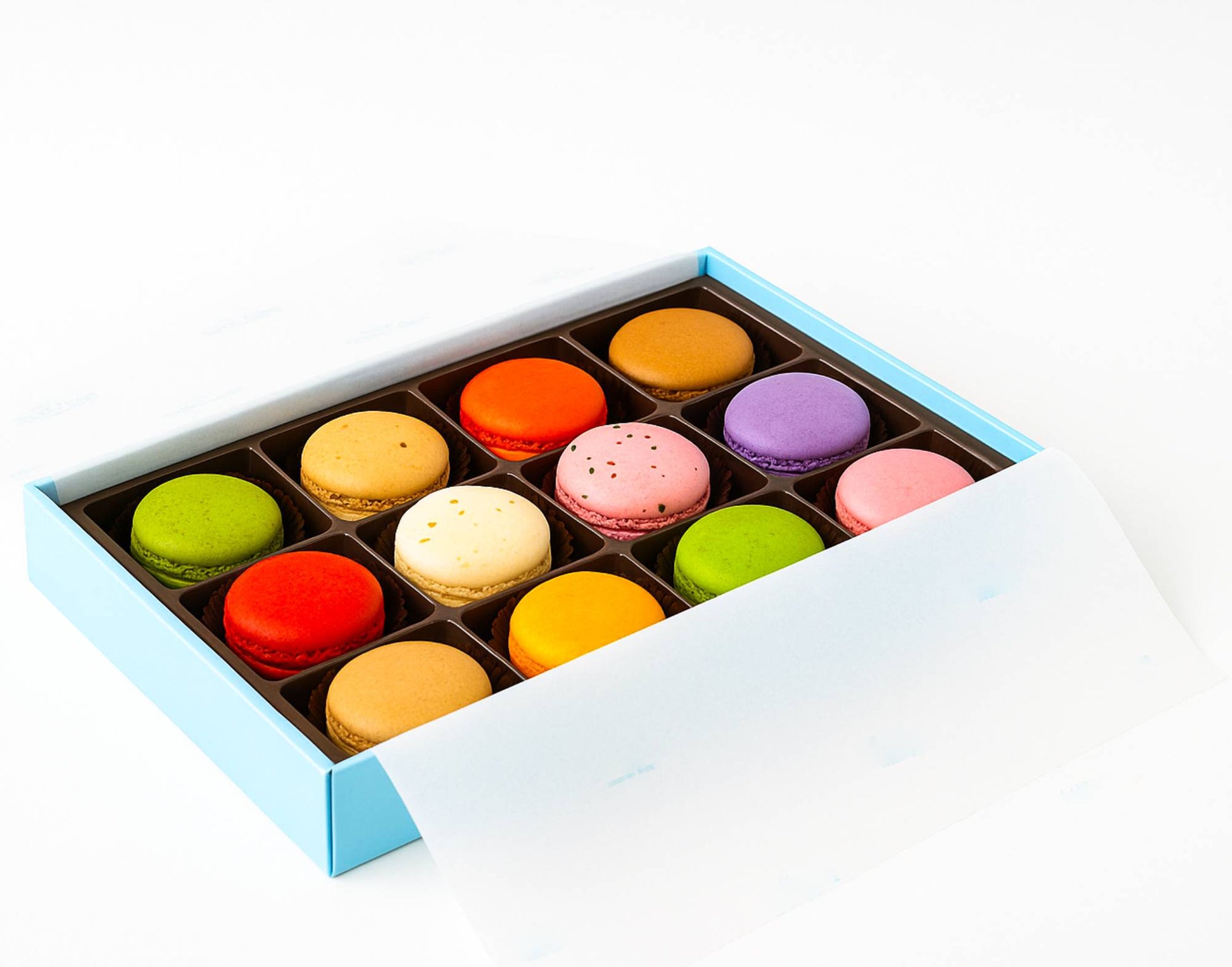 Box of colorful macarons on a white background