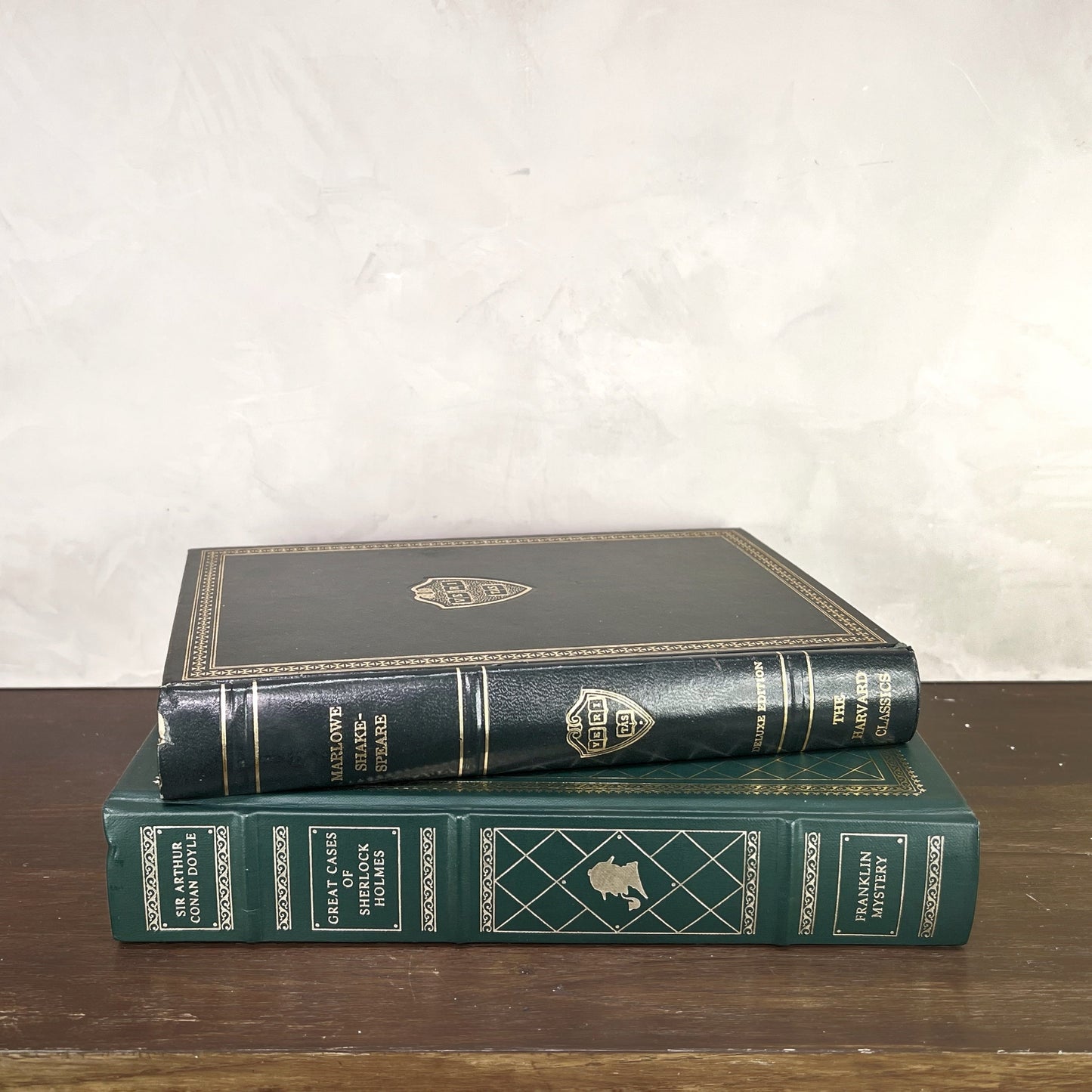 Vintage Green Gilded Books displayed on a wooden shelf, showcasing elegant bindings and beautiful gilding.