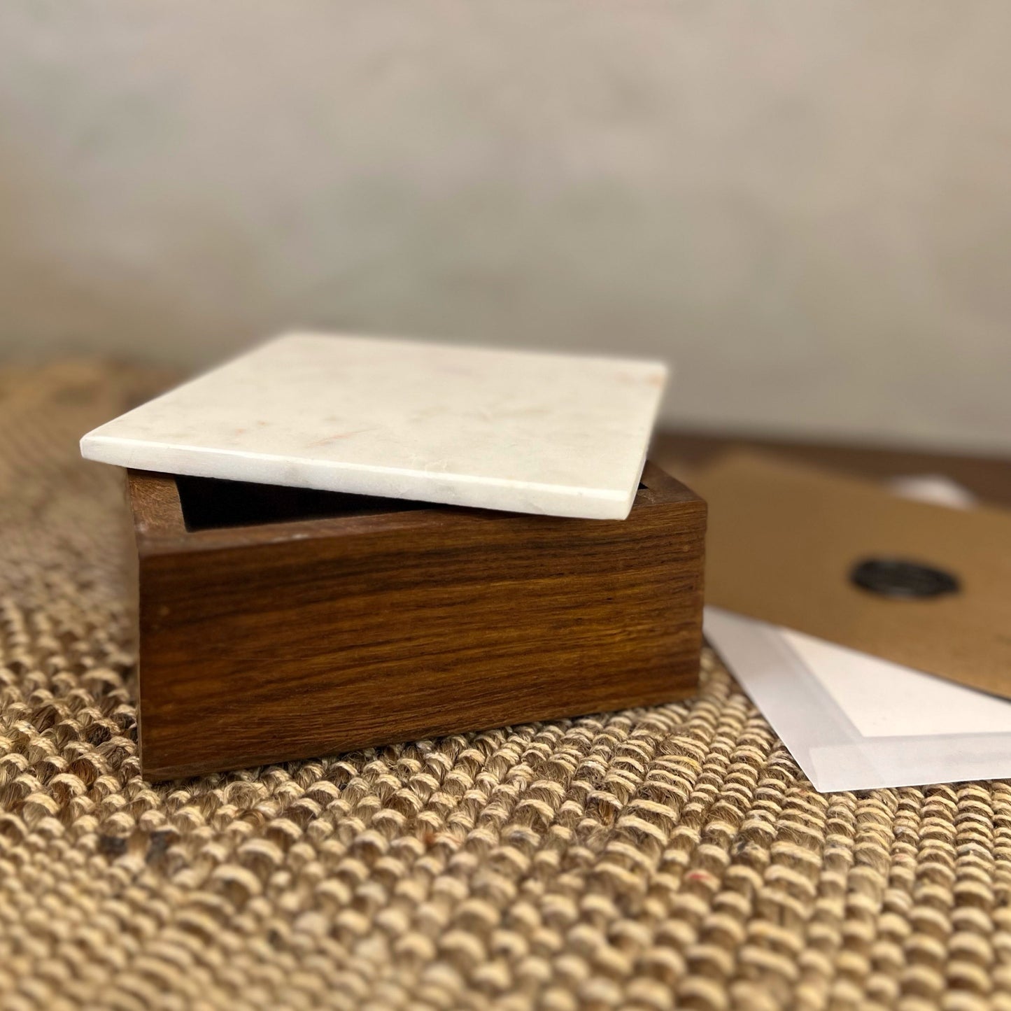 Maeve Wood and Marble Box with a removable marble lid on a textured surface.