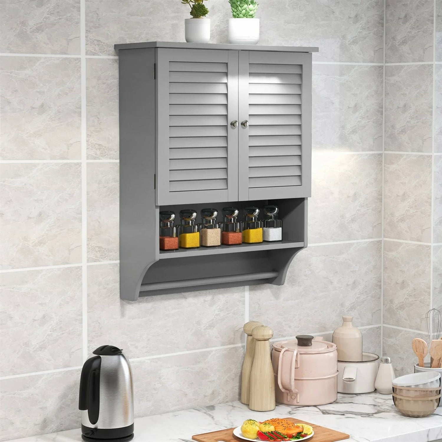 Gray wall-mounted cabinet with spice jars on a tiled kitchen wall.