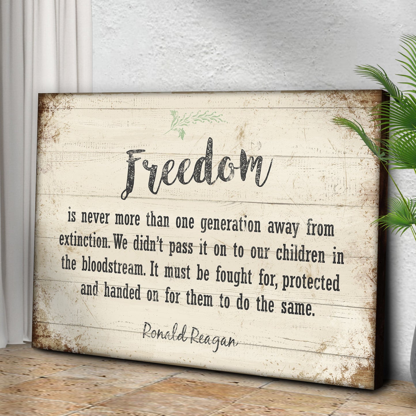 Wooden sign with a quote about freedom by Ronald Reagan on a white wall.