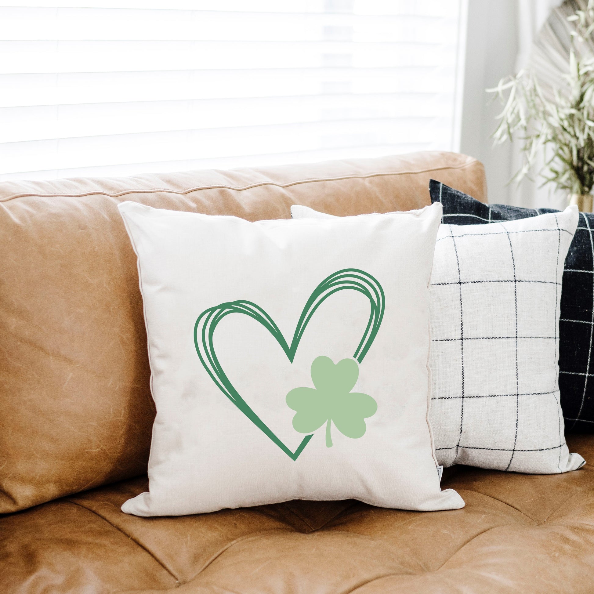 Heart with Clover 18x18 inch St Patrick's Day Pillow Cover on a couch, perfect for festive decor.