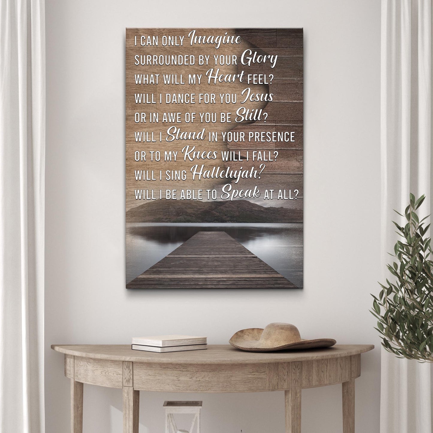 Wooden wall art with inspirational quote on a white wall above a wooden table.