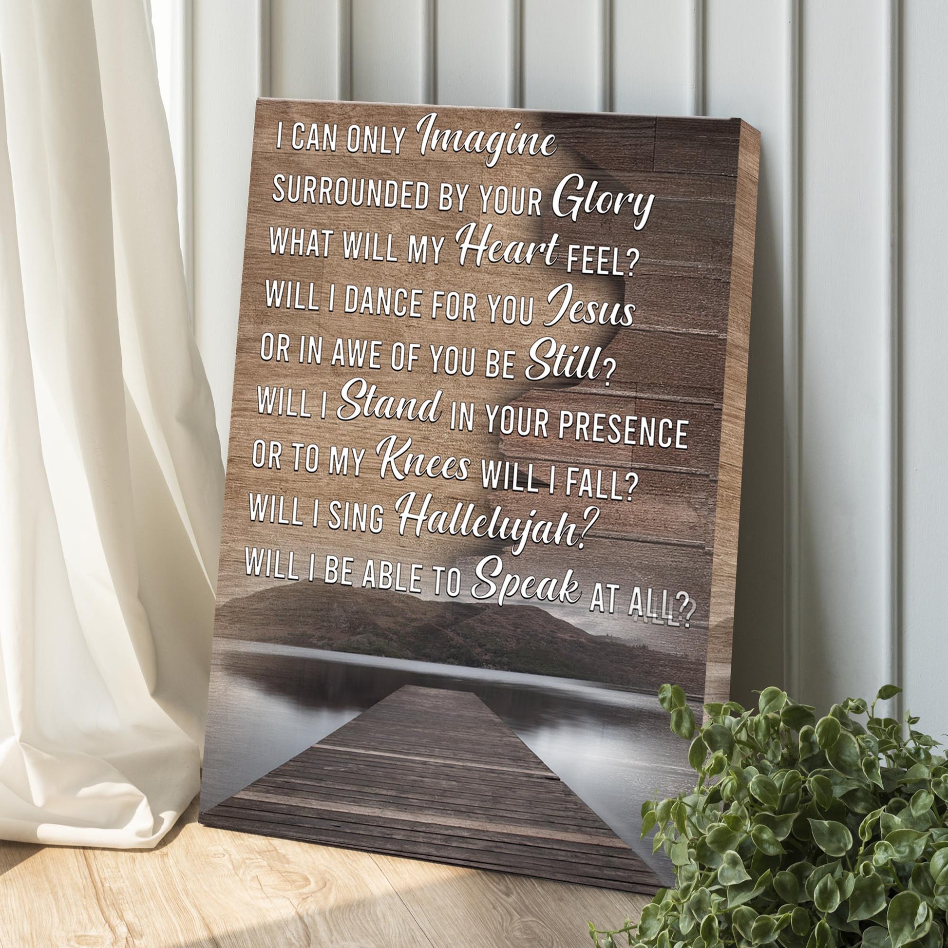 Wooden plaque with engraved text on a wooden stand, with a plant and curtain in the background.