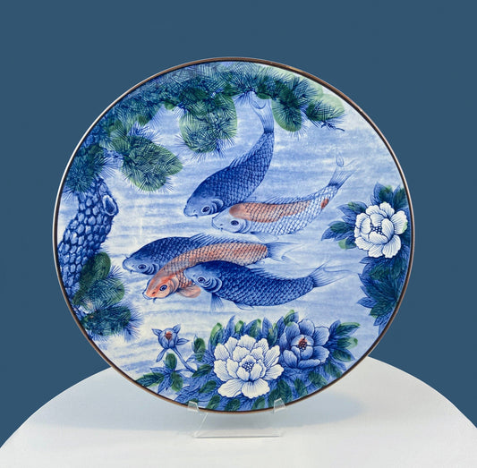 Decorative plate with fish and floral design on a blue background