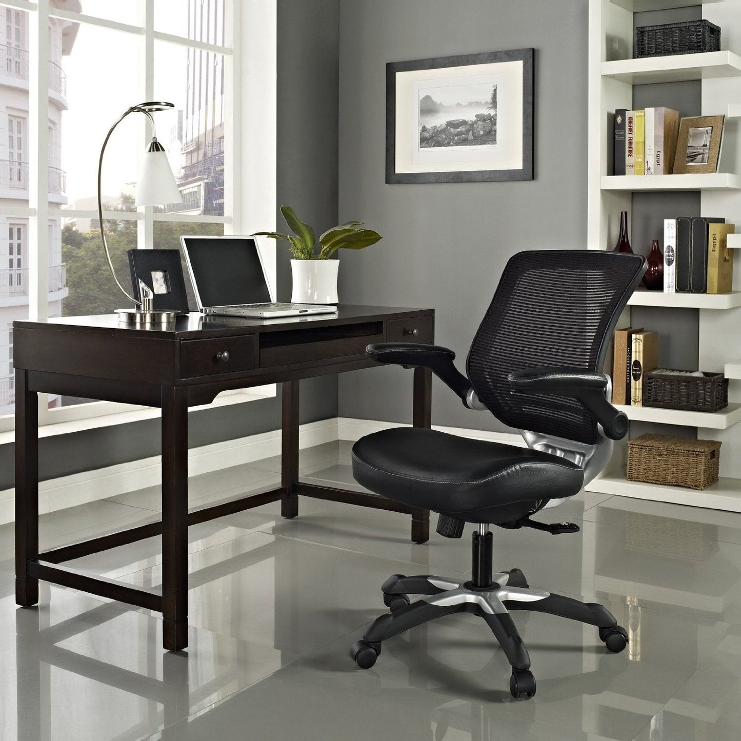 Modern office setup with a black desk and chair in a well-lit room.