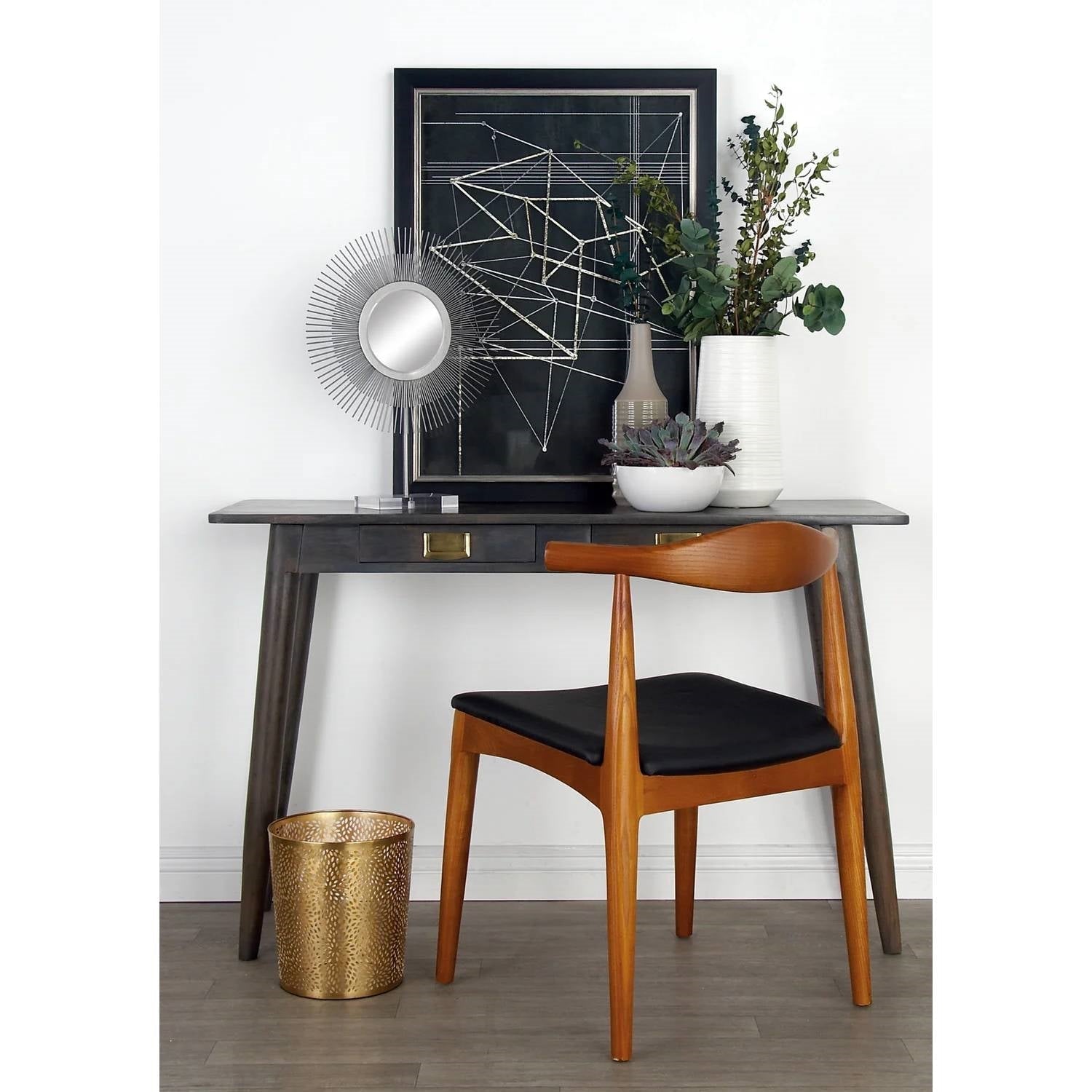 Wooden chair with black cushion in front of a wooden desk with decorative items.