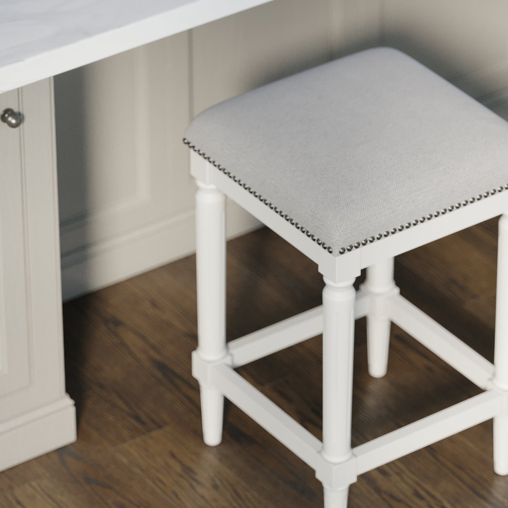 Asheville Stool in Solid White with grey linen cushion and nail head trim, adding modern design to kitchen decor.