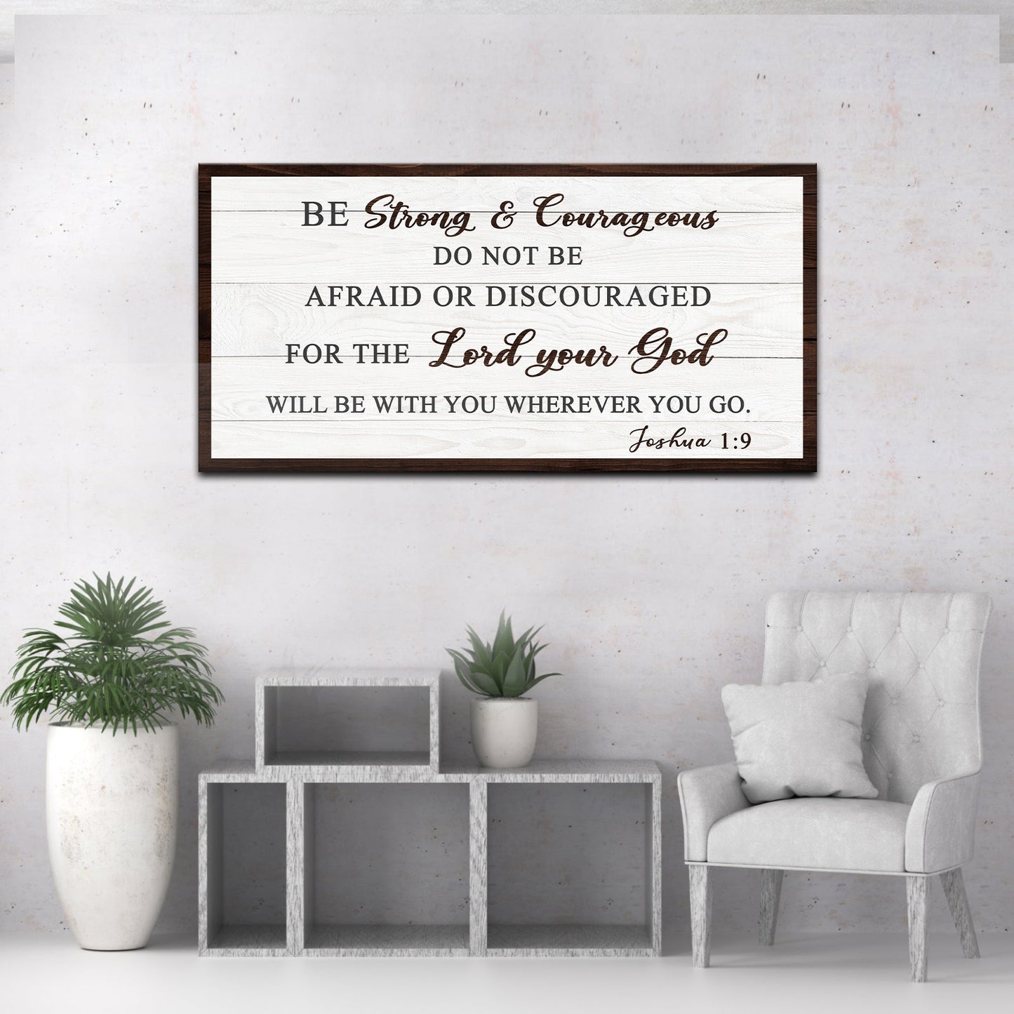 Decorative wall sign with Bible verse Joshua 1:9 in a living room setting