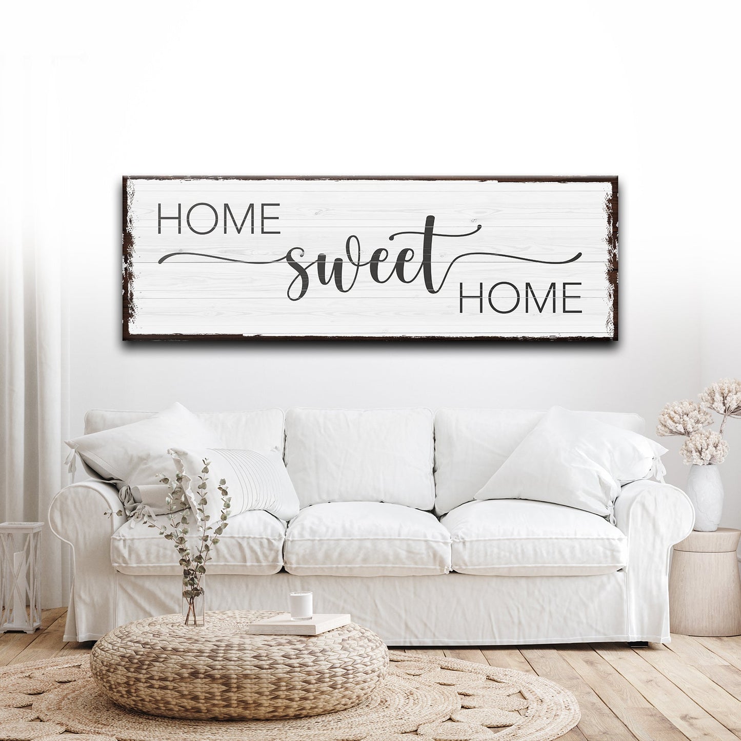 White sofa in a living room with a 'Home Sweet Home' sign above it.