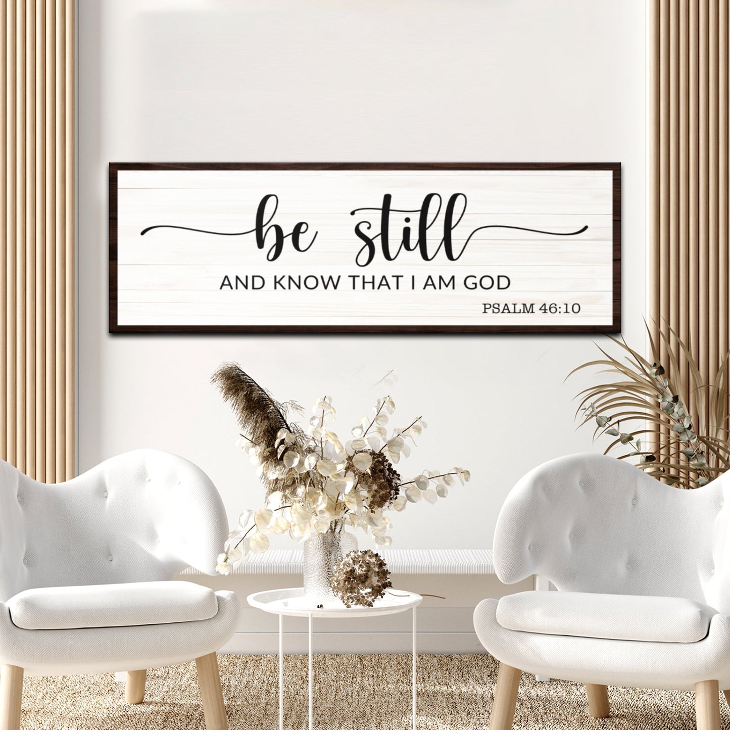 Framed artwork with 'be still and know that I am God' text in a living room setting.