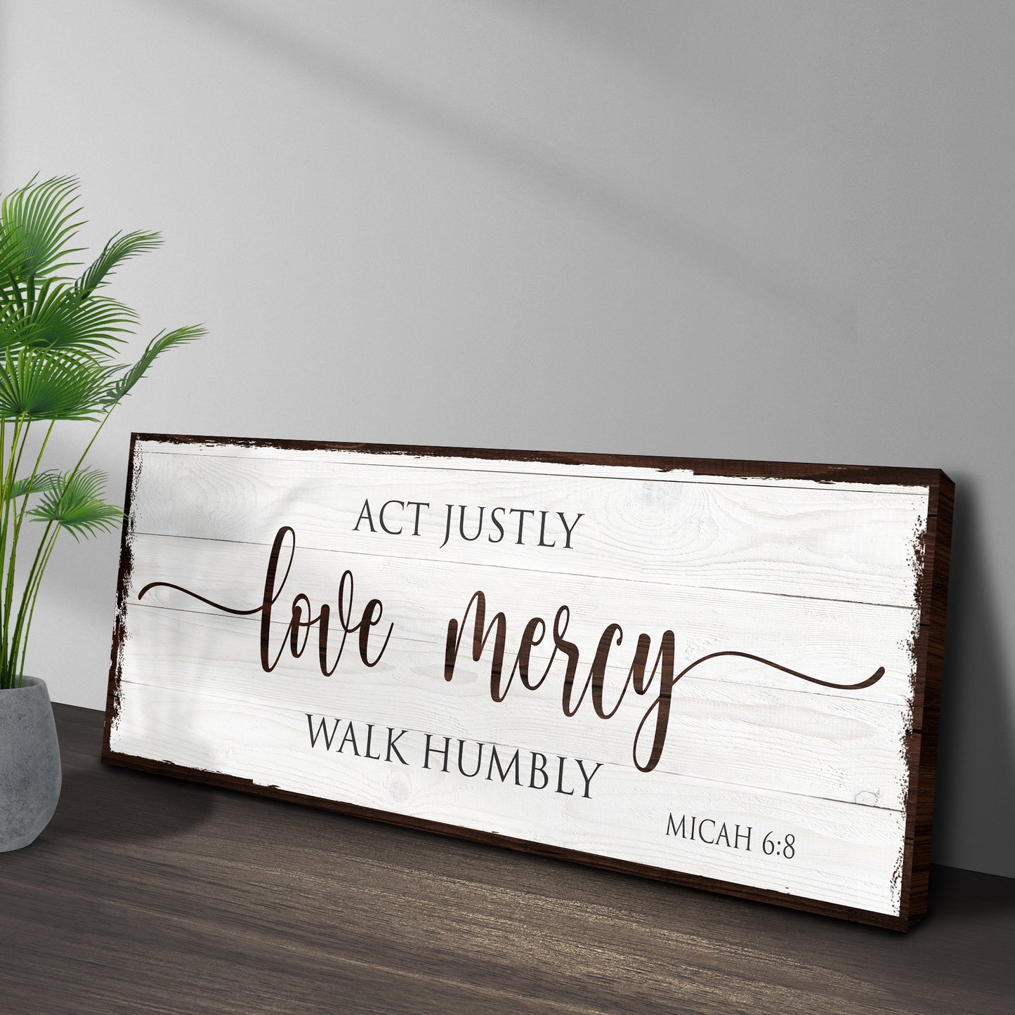 Wooden sign with Bible verse 'Act justly, love mercy, walk humbly' on a neutral background