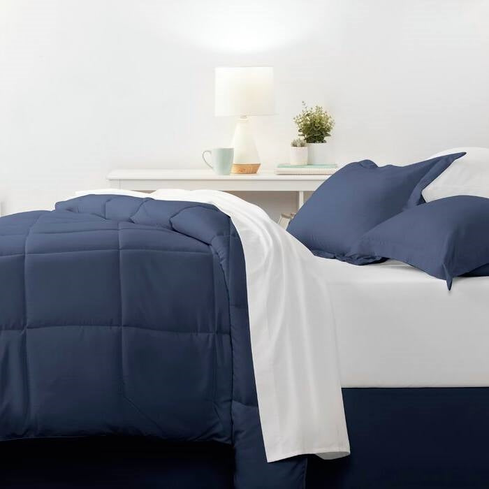 Twin Microfiber 6-Piece Reversible Bed-in-a-Bag Comforter Set Navy on a bed with matching pillows and sheets.