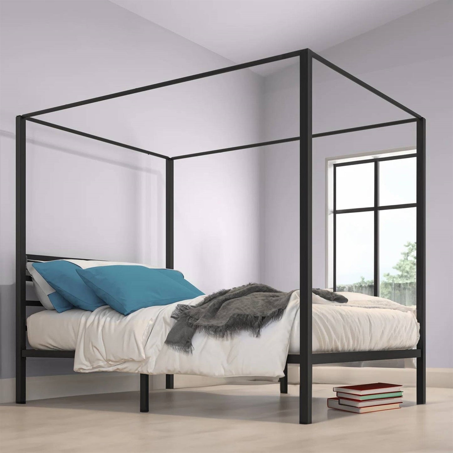 Black metal canopy bed with bedding in a room with a window.