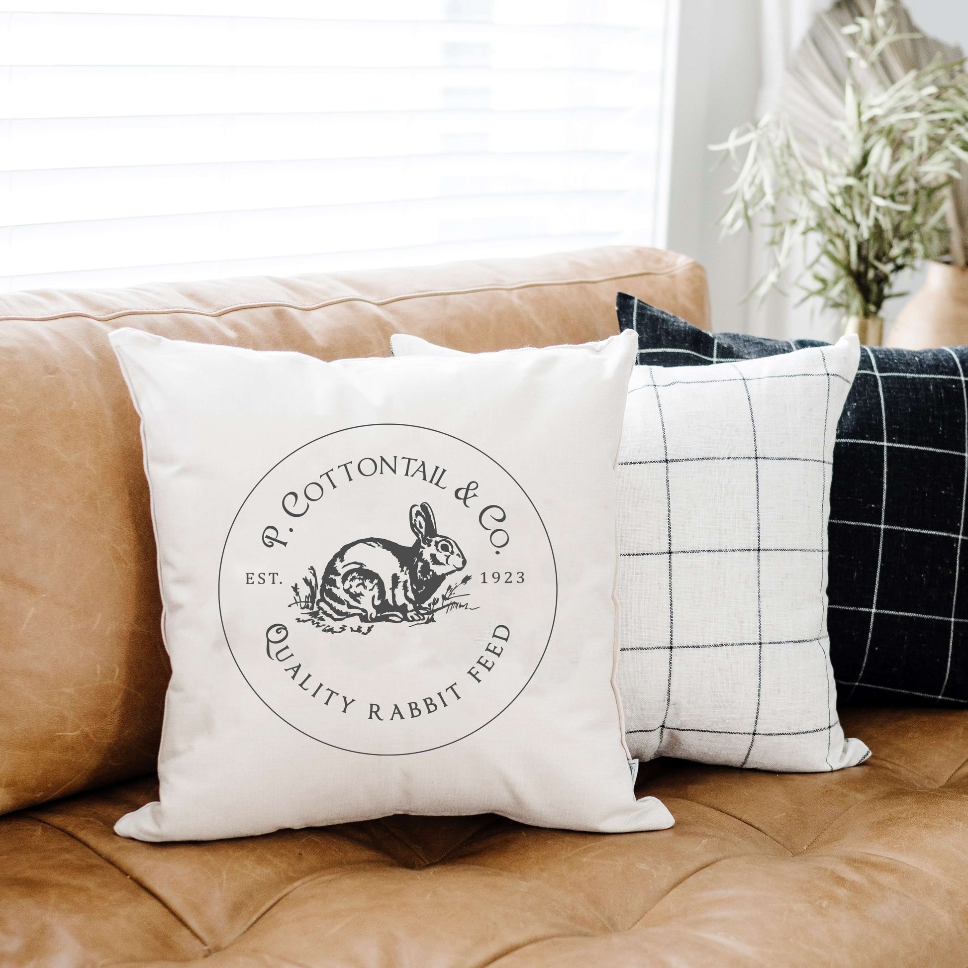 P. Cottontail Co. Feed Spring Pillow Cover on a cozy couch with a bunny design and accent pillows