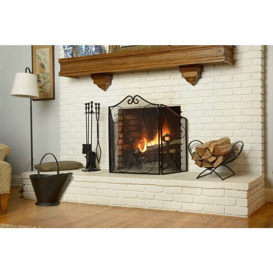 Fireplace with firewood, tools, and a white brick wall.