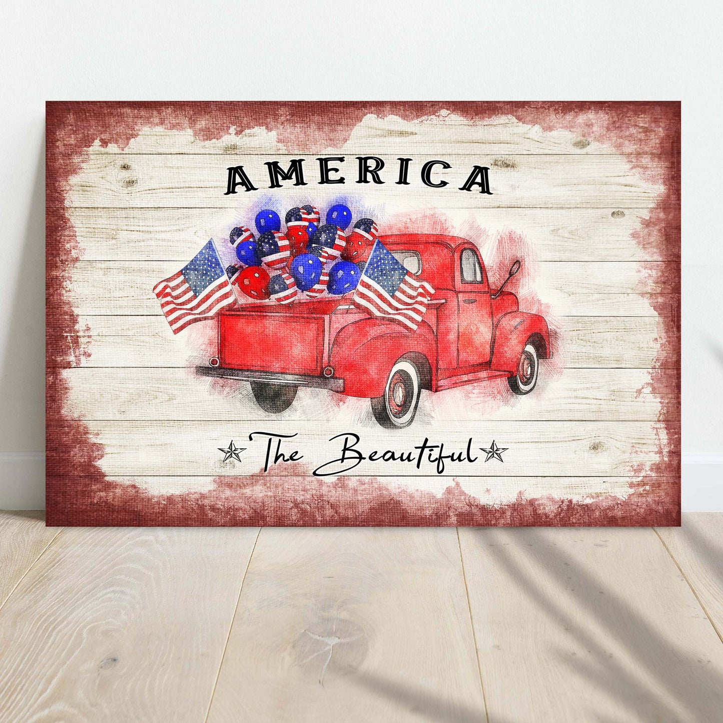Decorative sign with a red truck, American flags, and balloons on a wooden background.