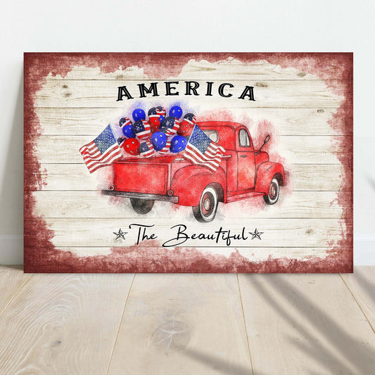 Decorative sign with a red truck, American flags, and balloons on a wooden background.