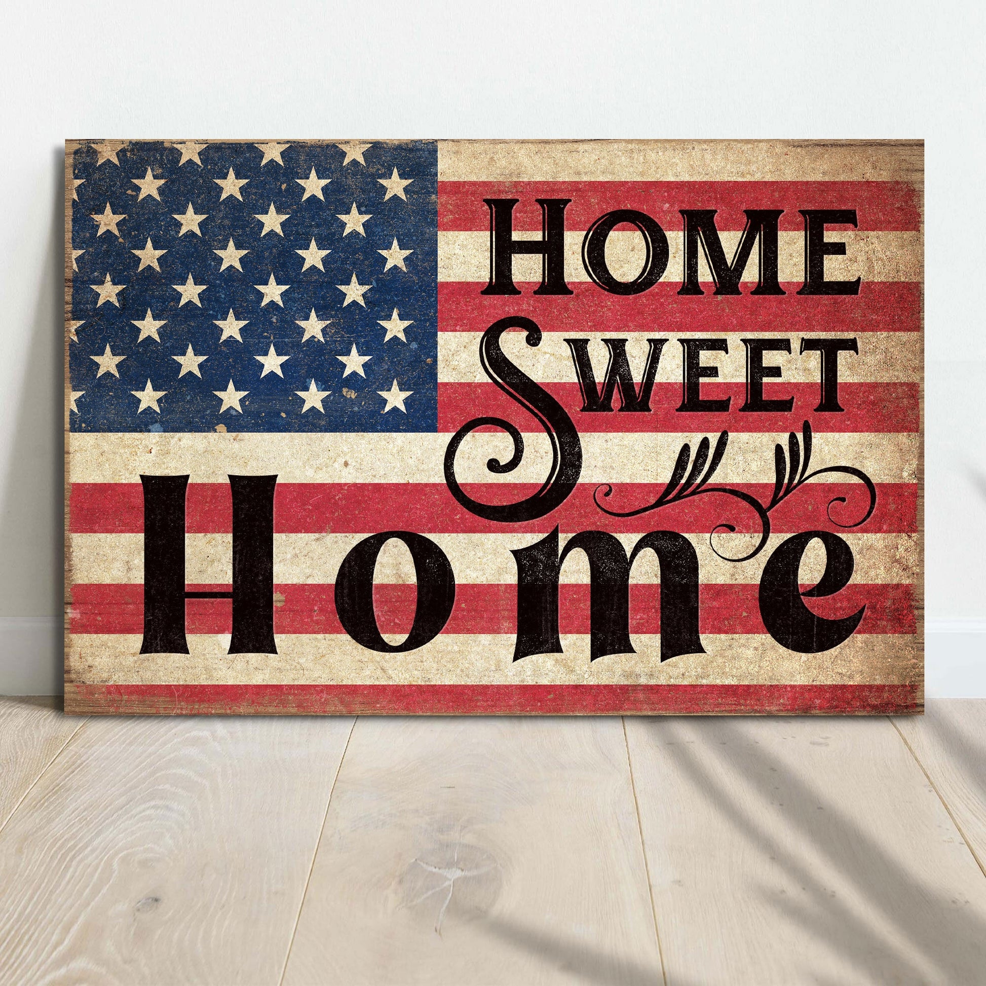 Decorative sign with American flag and 'Home Sweet Home' text on a wooden surface.