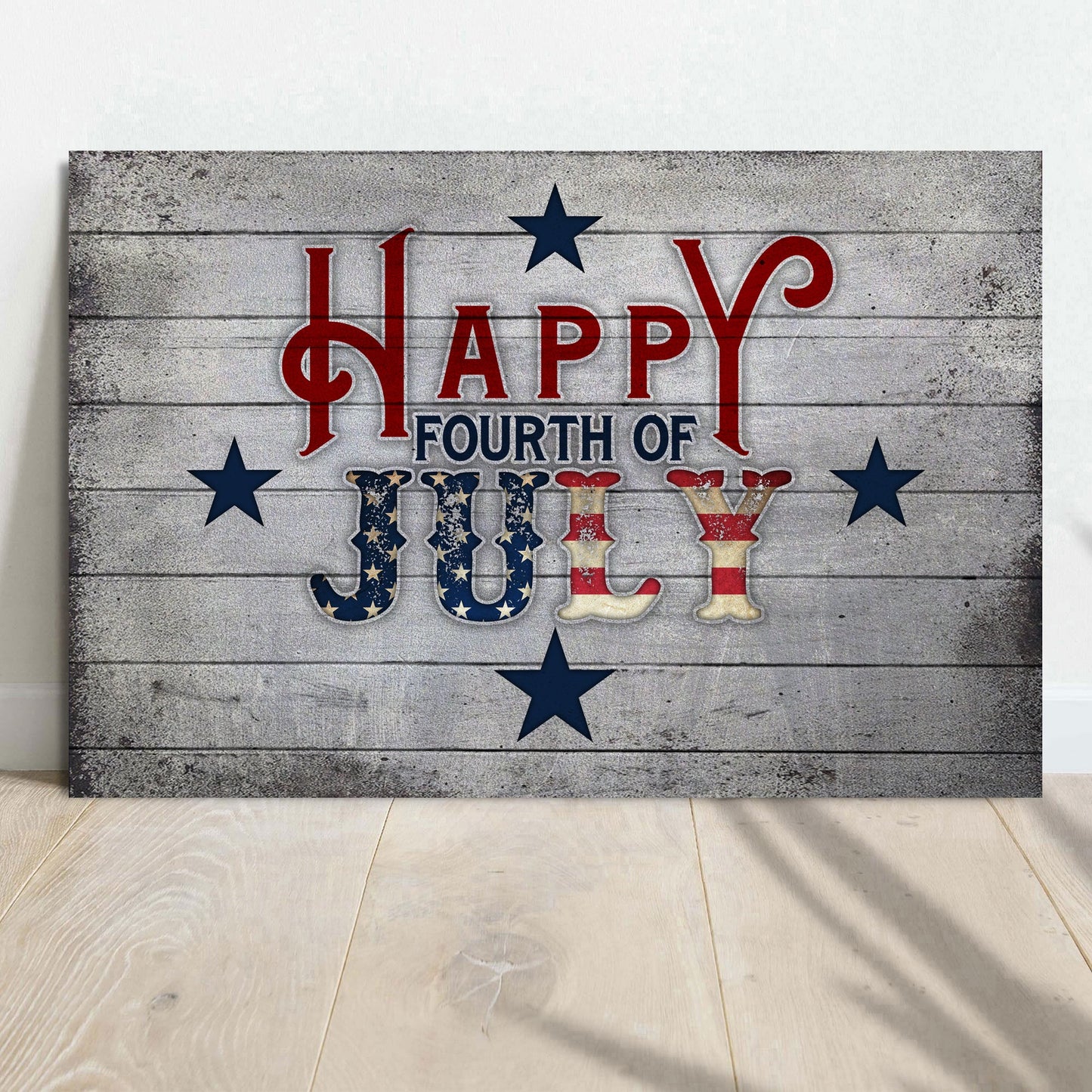 Wooden sign with 'Happy Fourth of July' text on a wooden floor.