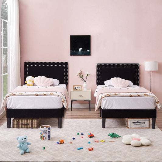 Children's bedroom with two beds, toys on the floor, and a pink wall.