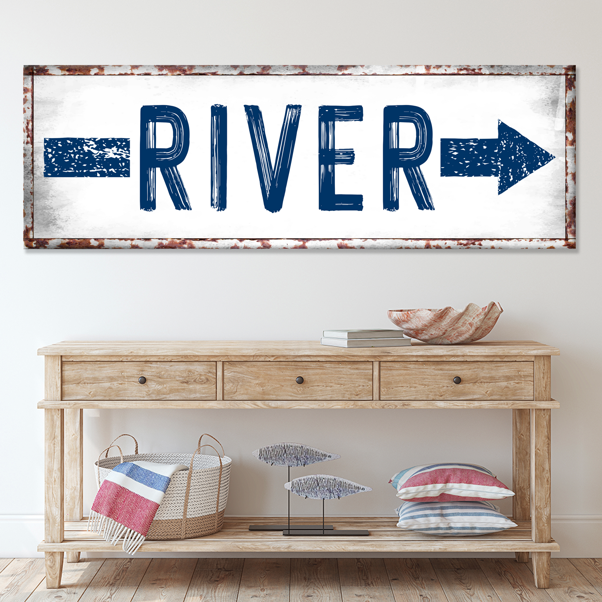 Decorative sign with 'RIVER' and arrows above a wooden console table.