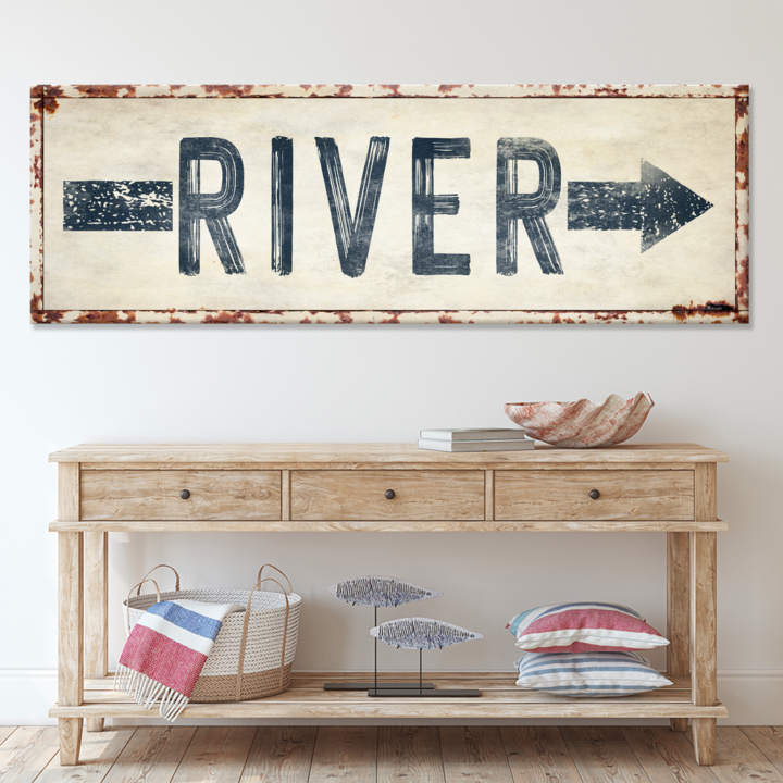 Wooden console table with decorative items and a 'River' sign above it.