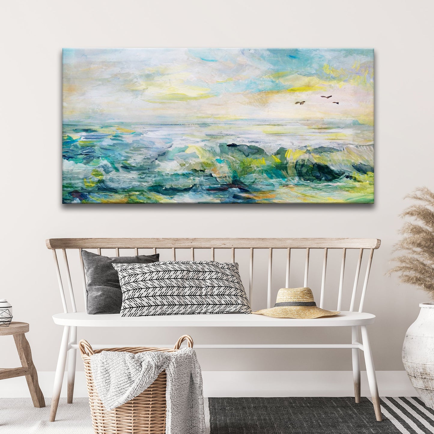 Painting of a coastal scene with waves and sky above a bench with pillows and a hat.