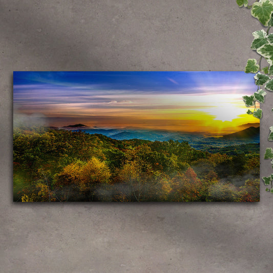 Landscape print of a sunset over a forest on a textured wall.