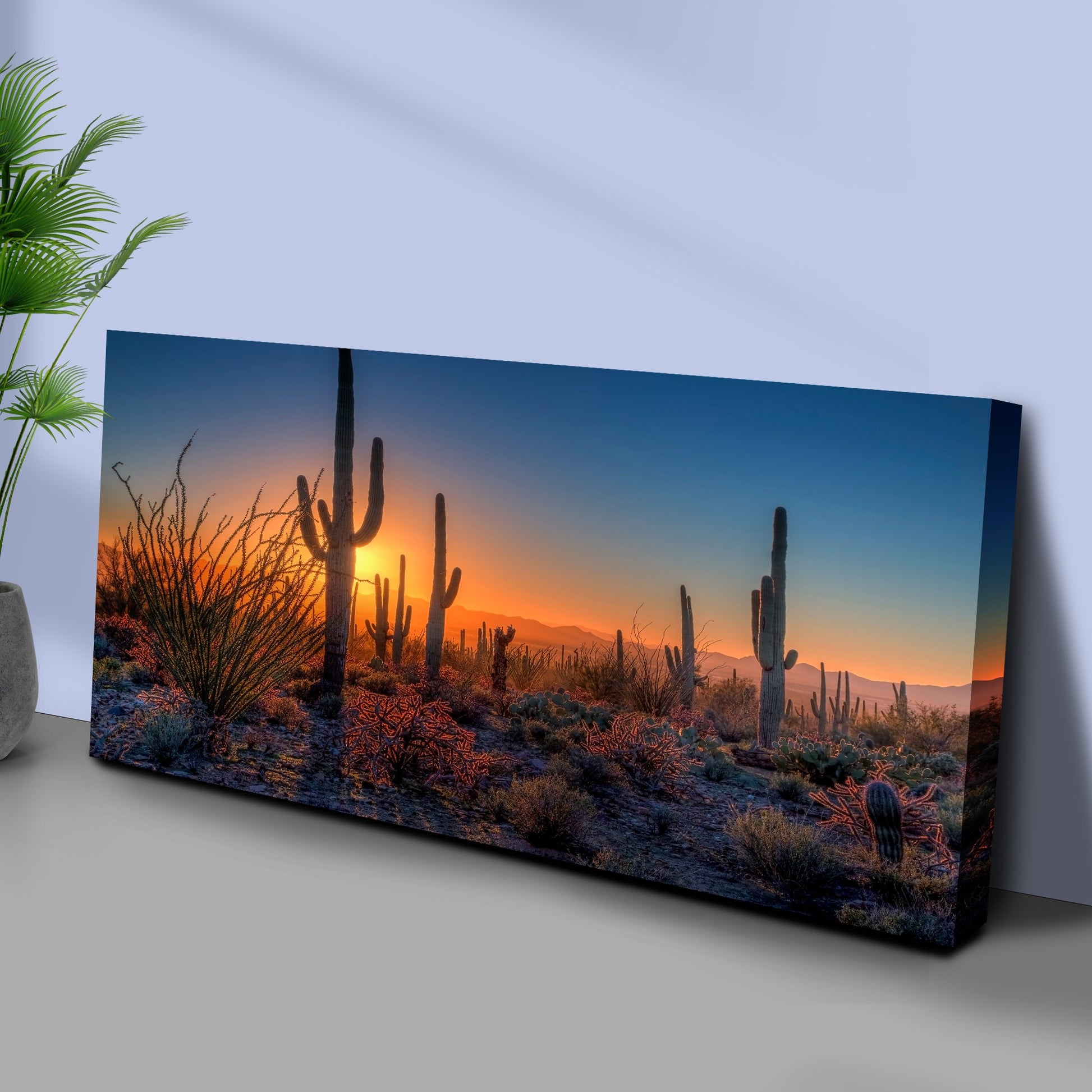 Canvas print of a desert landscape with cacti and sunset on a wall.