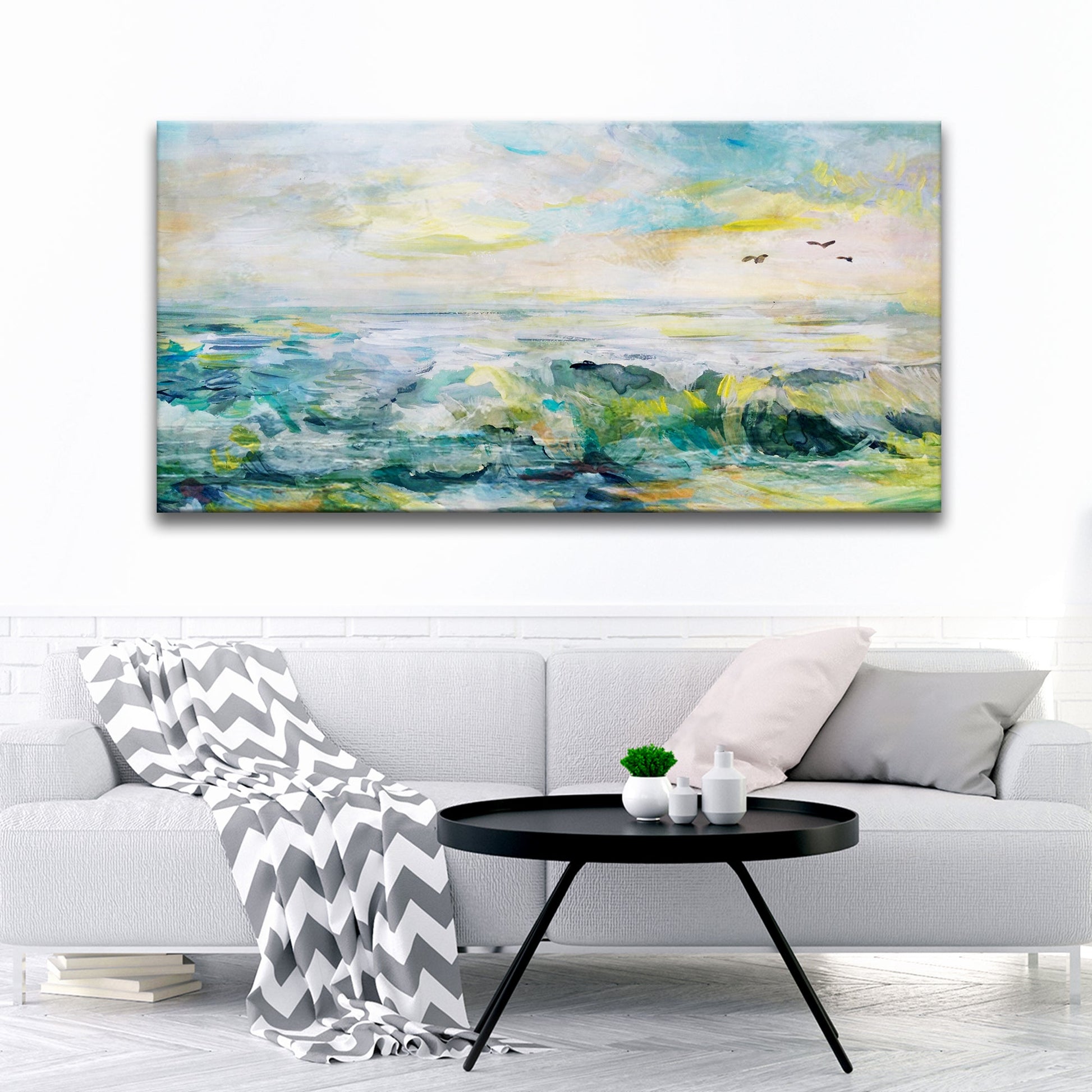 Large abstract painting of a seascape above a white sofa in a living room.