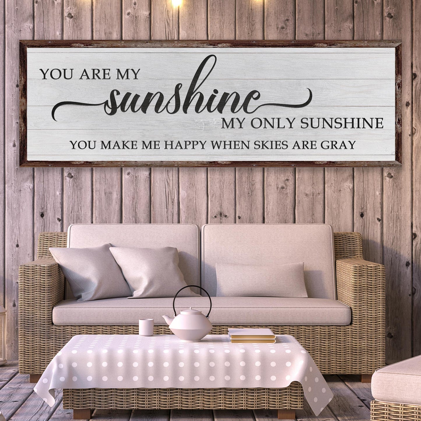 Decorative sign with 'You are my sunshine' quote above a sofa and coffee table.