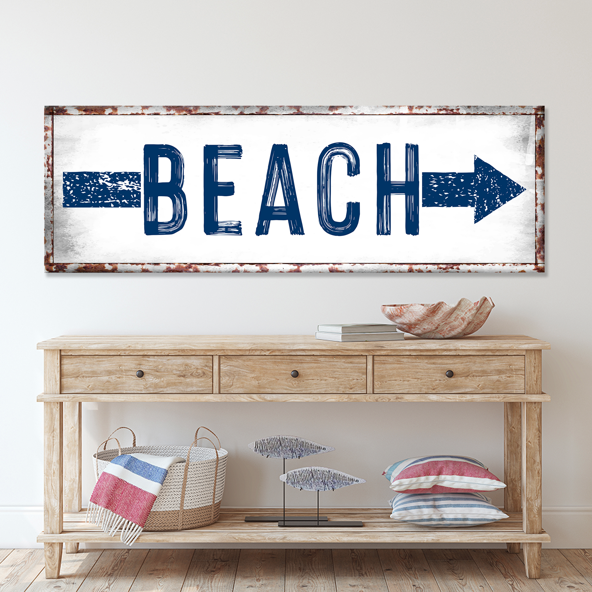 Decorative 'BEACH' sign with an arrow above a wooden console table.