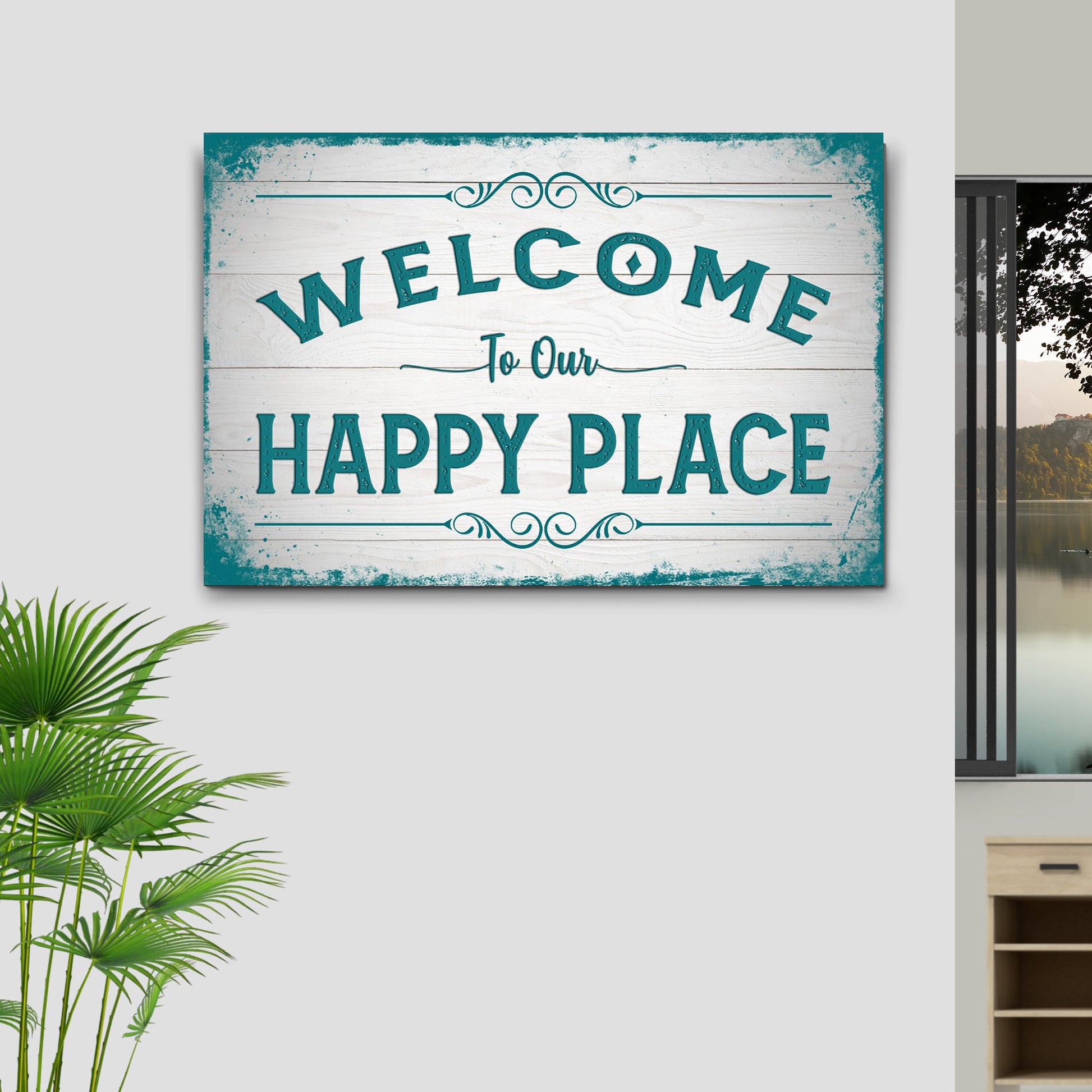 Decorative sign with 'Welcome to Our Happy Place' text on a wall with a plant and window in the background.