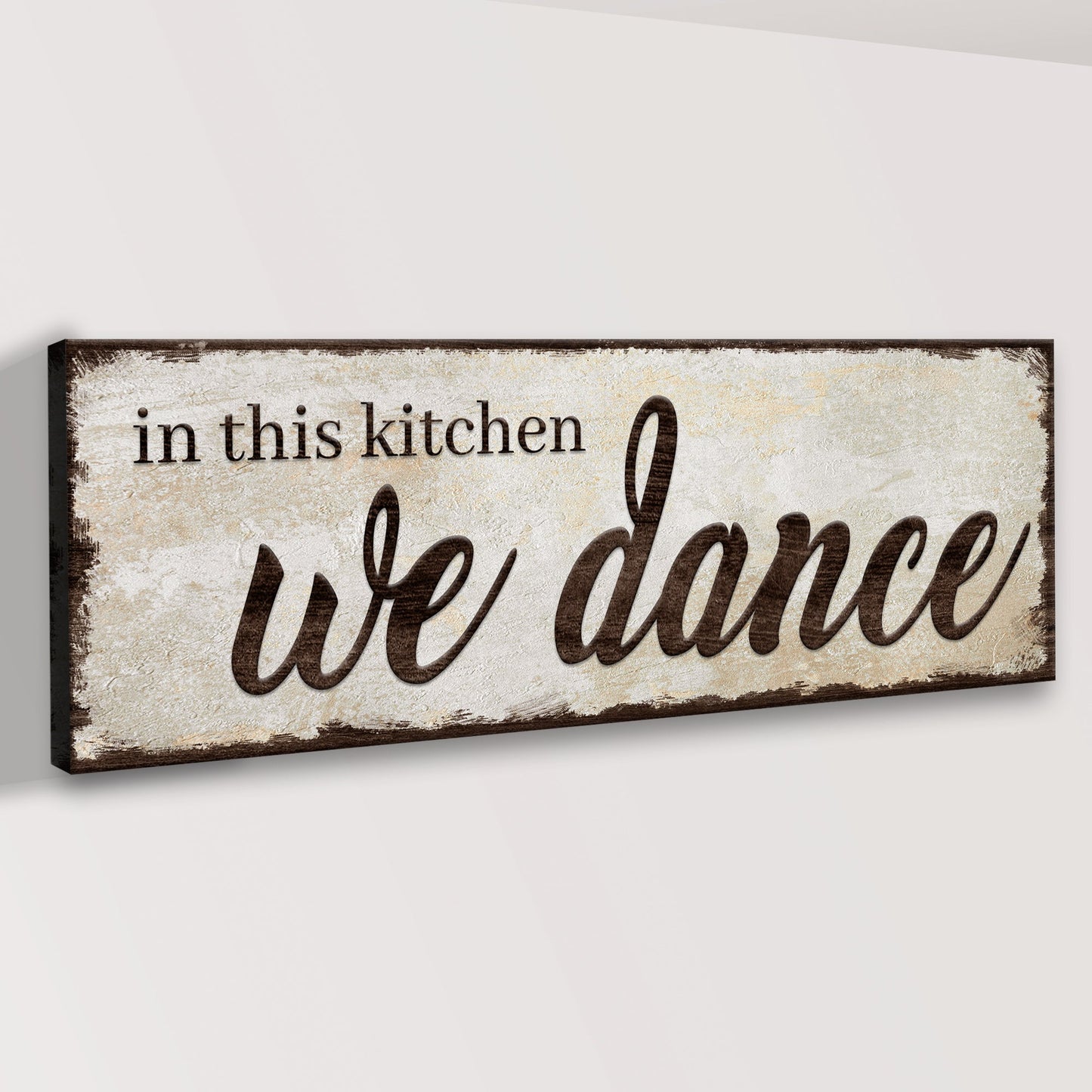 Decorative sign with 'in this kitchen we dance' text on a white background