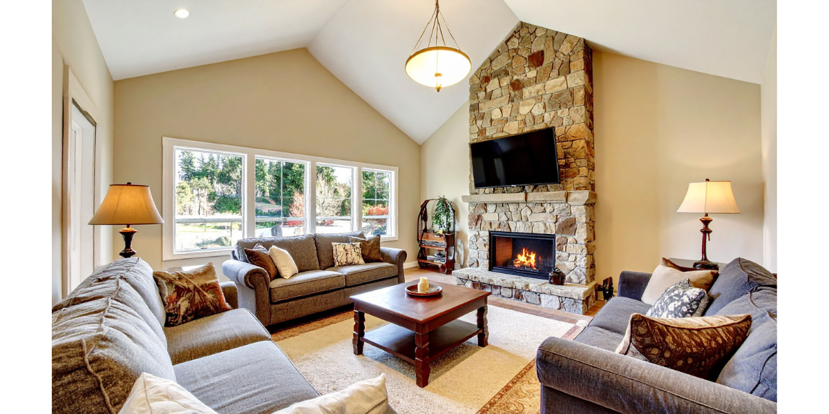 Living room with stone fireplace, couches, and a TV.