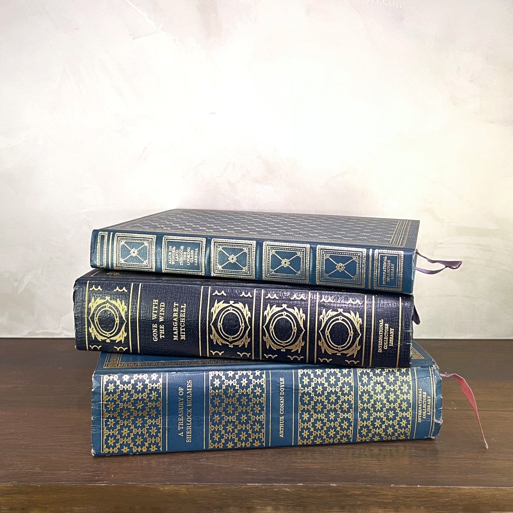 Vintage Blue Gilded Books stacked with ornate gilded designs on the covers, showcasing their elegant bindings.