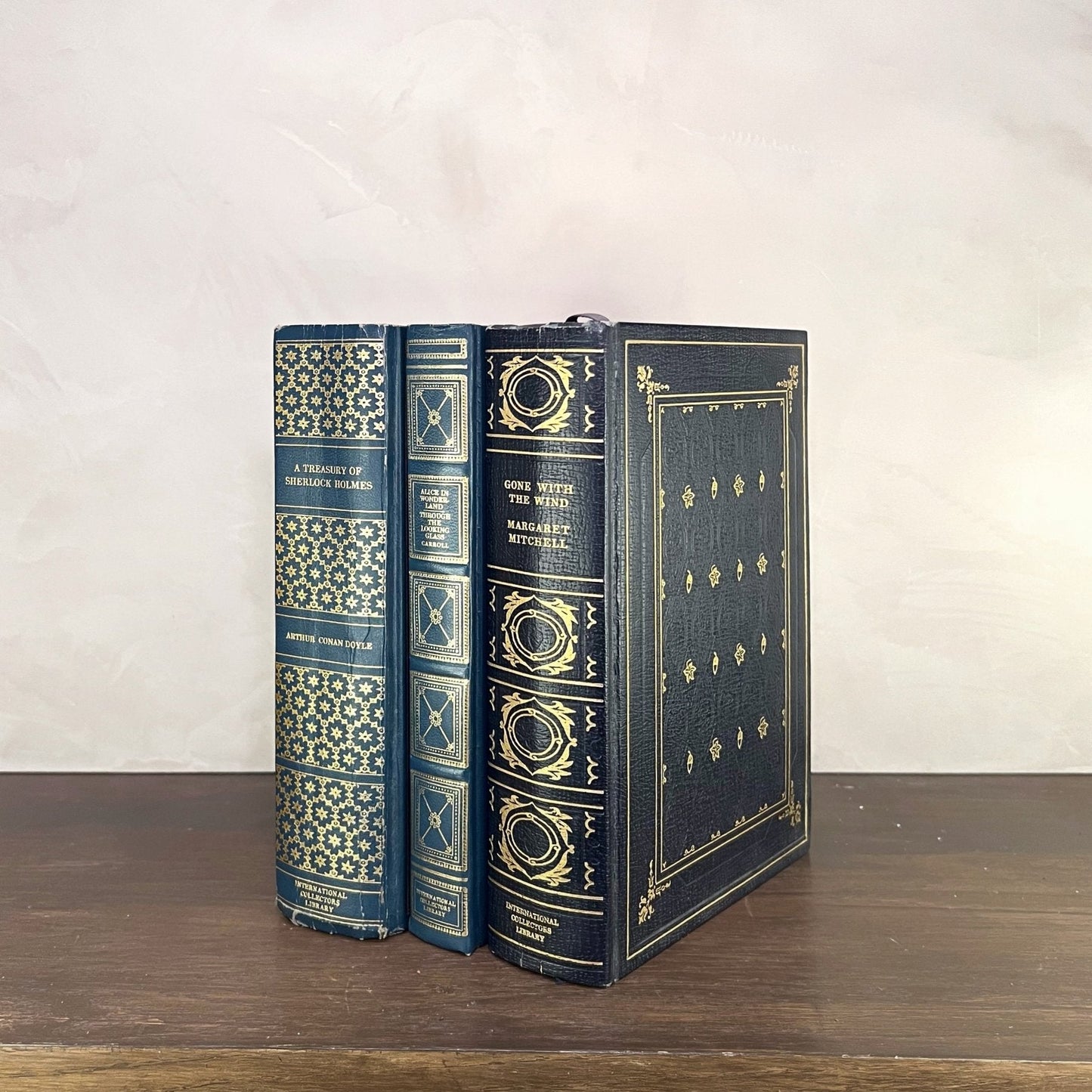 Vintage Blue Gilded Books displayed beautifully on a wooden shelf with intricate gilded bindings.