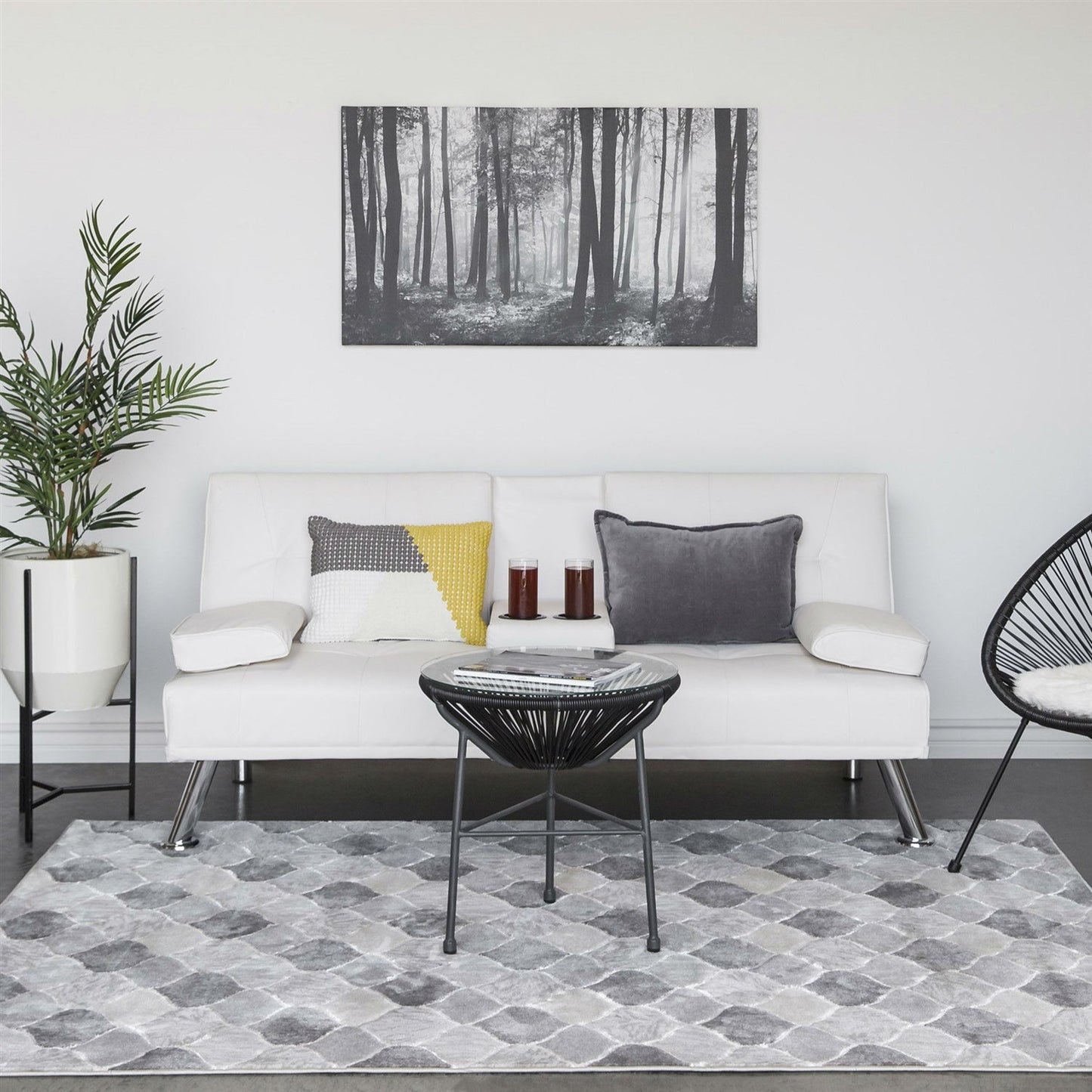 Modern living room with a white sofa, decorative pillows, and a forest-themed wall art.