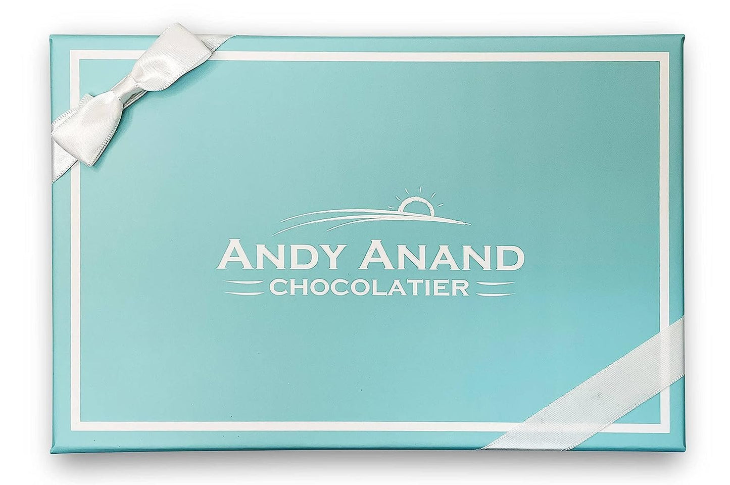 Blue box with white ribbon and 'Andy Anand Chocolatier' logo on a white background