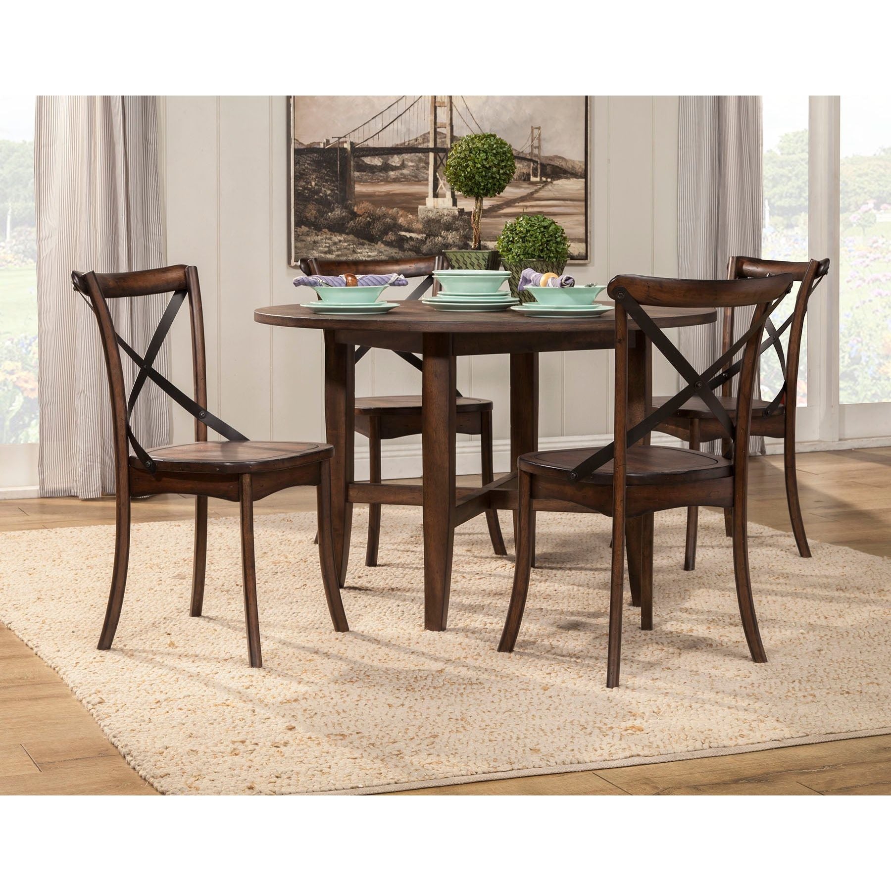 Arendal Round Table in Dark Burnished Oak with metal cross-back chairs, perfect for rustic and industrial dining.