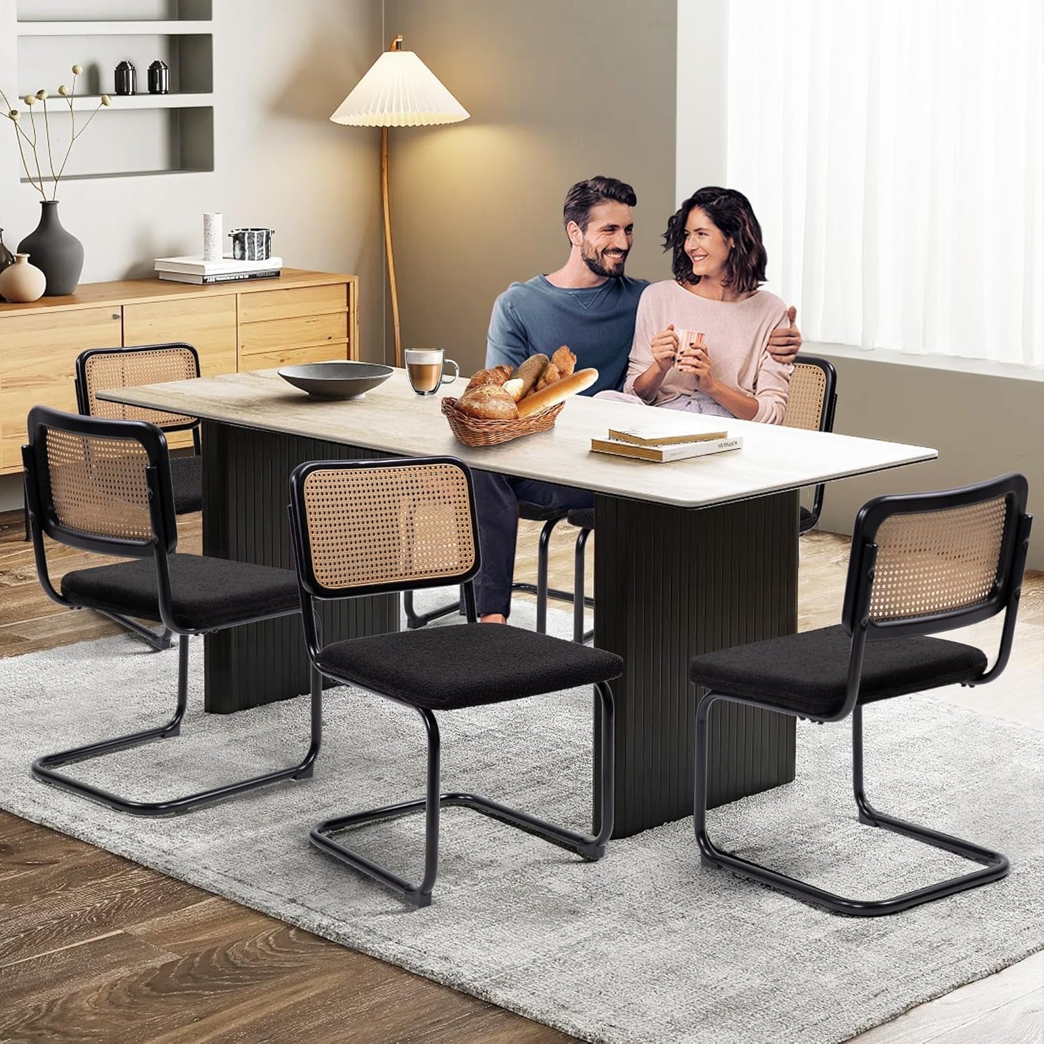 Cesca Cane Dining Chairs Set of 2 Black Boucle Seat around a modern dining table with a couple enjoying a meal.