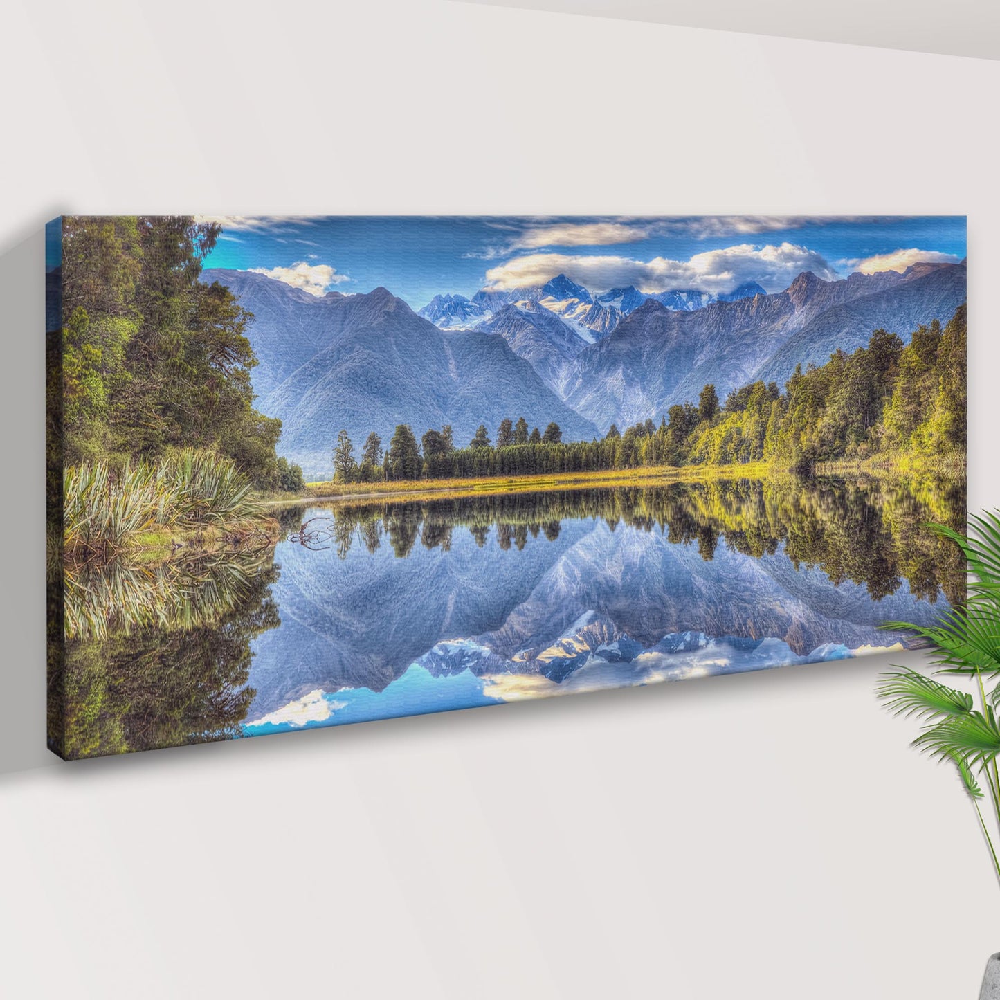 Canvas print of a mountain landscape with a lake on a white wall.