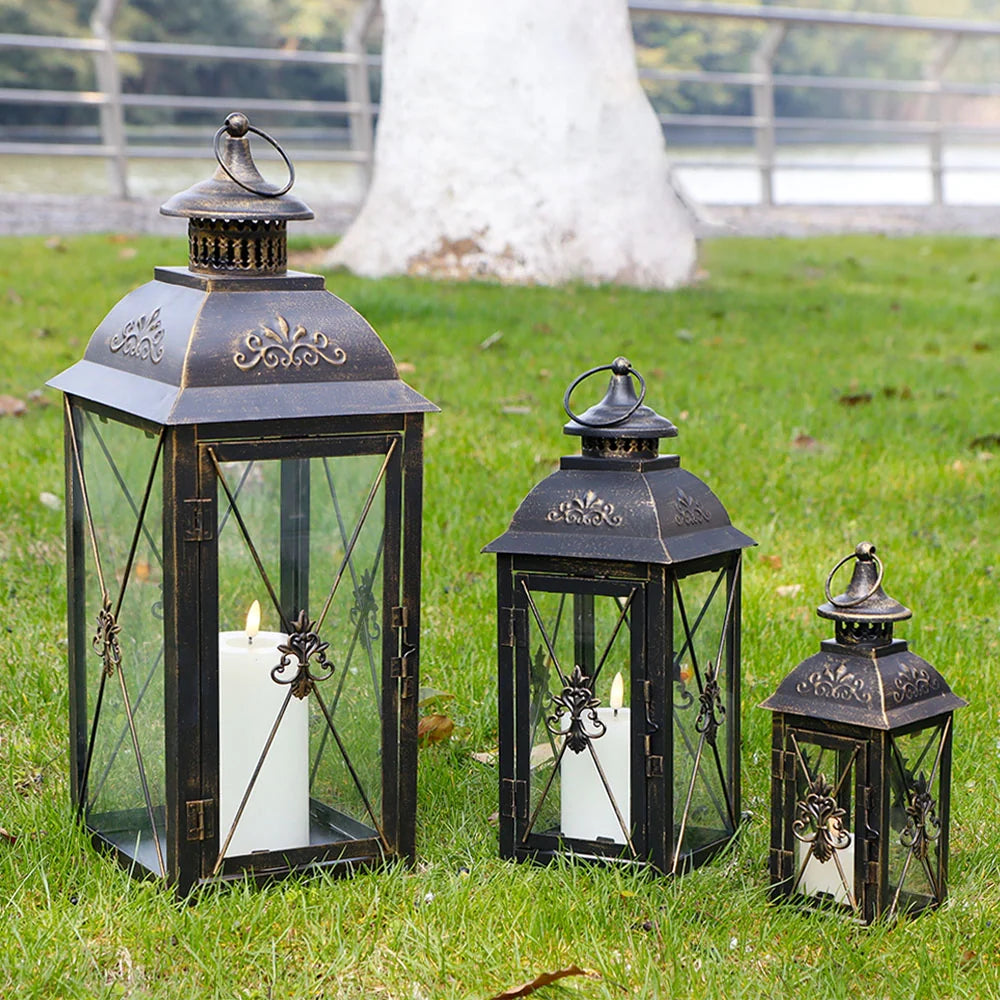 Set of 3- 19'' High Decorative Hanging Lantern Black 13.5'' & 9.5'' displayed in a garden with candles inside.