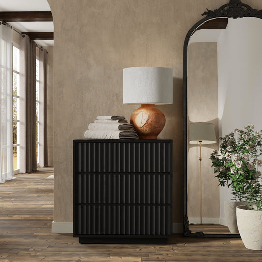 Blanca Small Chest in black with decorative lamp and towels in elegant interior setting.