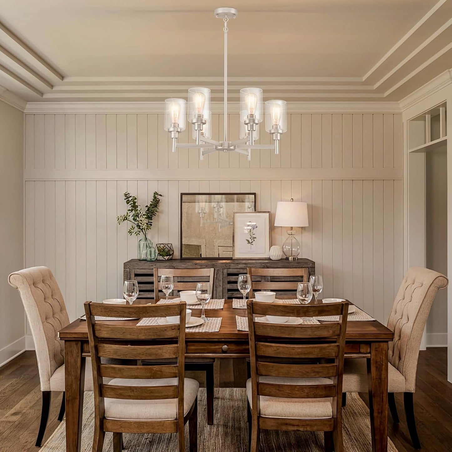 Brushed Nickel Six Light Chandelier With Clear Glass Shades illuminating a stylish dining room setting.