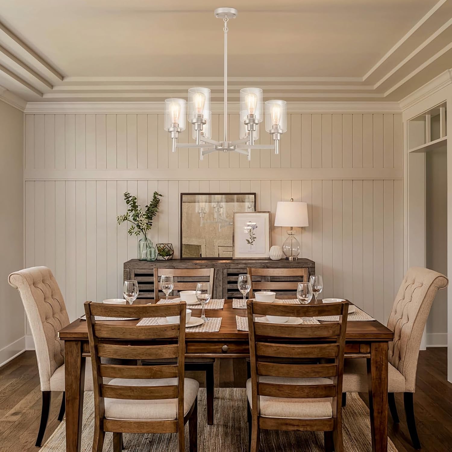 Brushed Nickel Six Light Chandelier With Clear Glass Shades illuminating a stylish dining room setting.