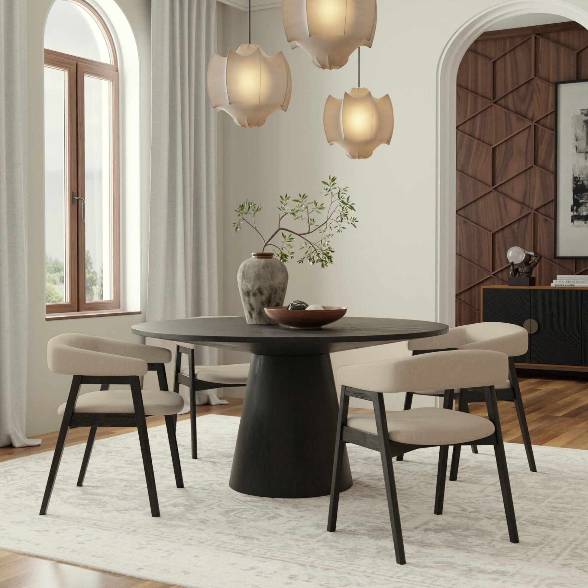 Cove Round Dining Table featuring a sleek pedestal base, surrounded by stylish chairs in a modern dining room setting.