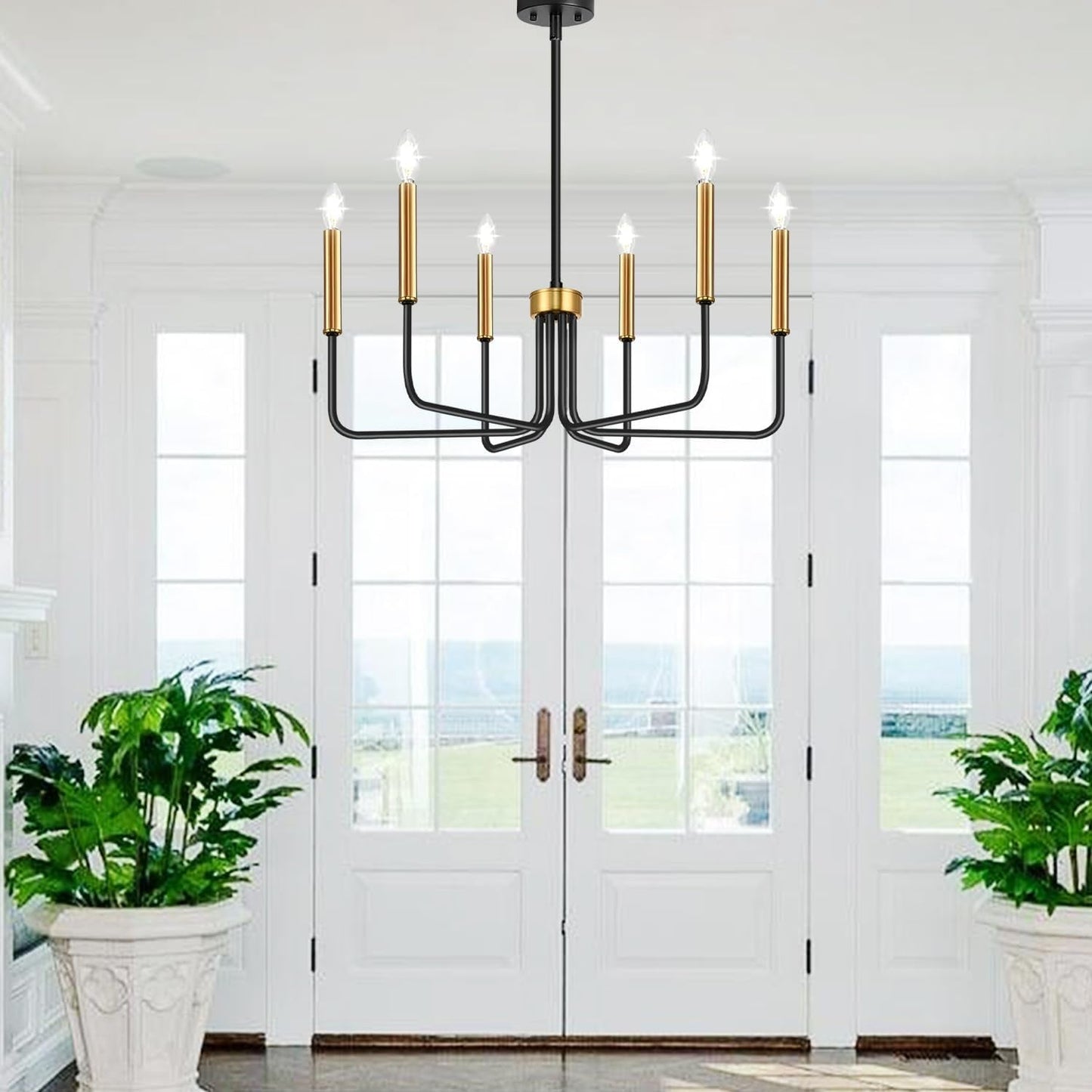 Black And Gold Six Light Farmhouse Chandelier For Dining Room hung in a bright entryway with large windows.