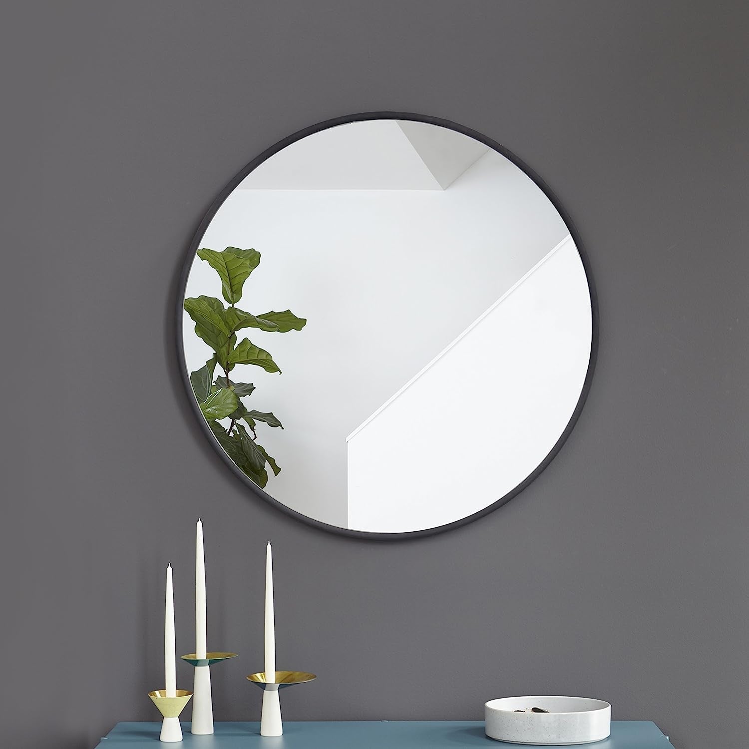 Round Rubber Wall Mirror 37 Inch diameter reflecting a modern interior with staircase and greenery.